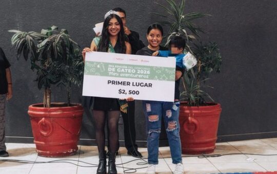 Joven con corona sostiene un cheque de primer lugar de $2,500 junto a una mujer con un pequeño, en el Concurso de Gateo
