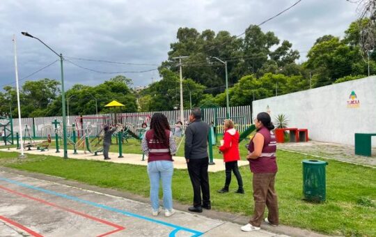 Cuatro personas, dos con chalecos guinda, observan el área de ejercicio del Polideportivo Adolfo López Mateos, Tlaxcala